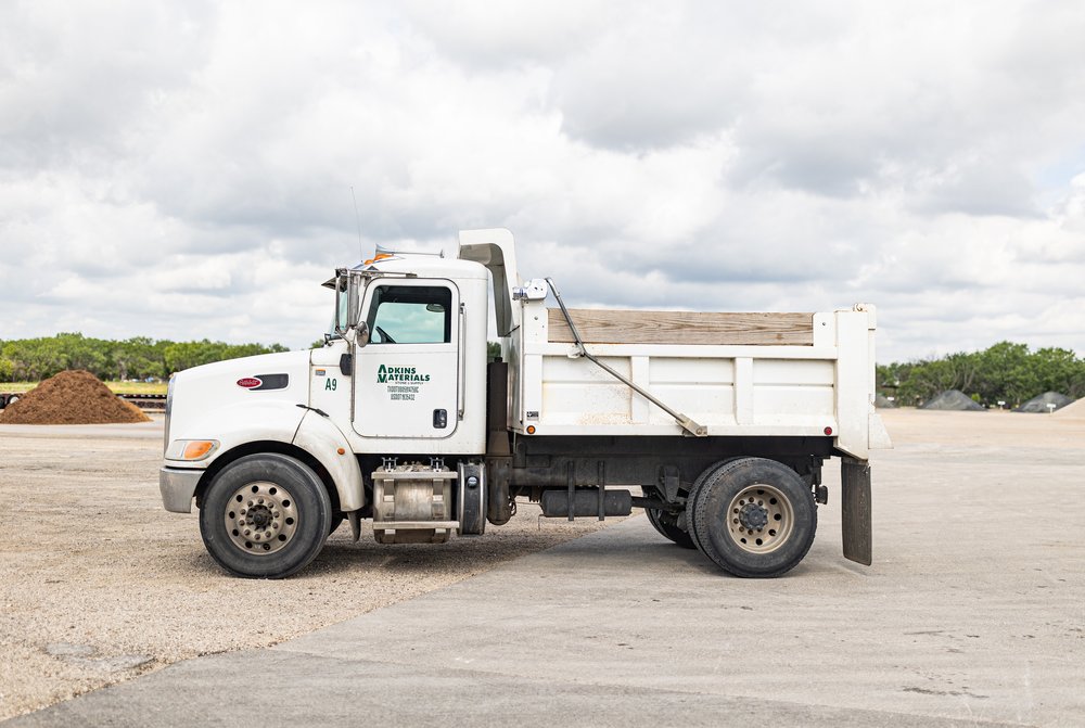 White dump truck parked on a construction site.